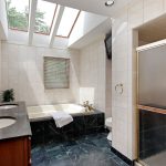 Vintage bathroom with green marble tile, skylight